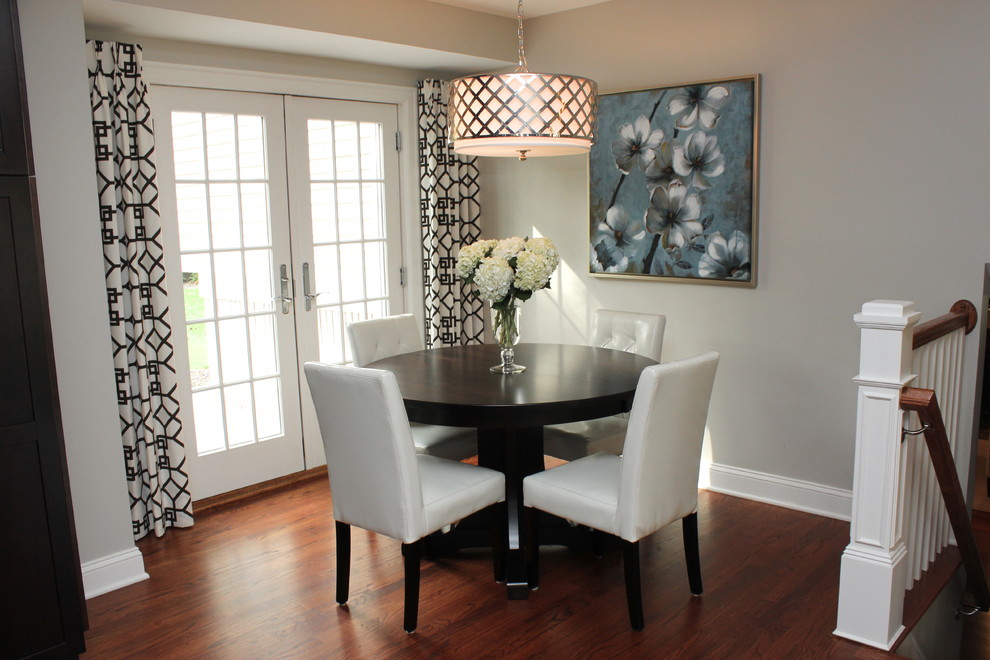 Cette image montre une salle à manger traditionnelle avec un mur gris et parquet foncé.