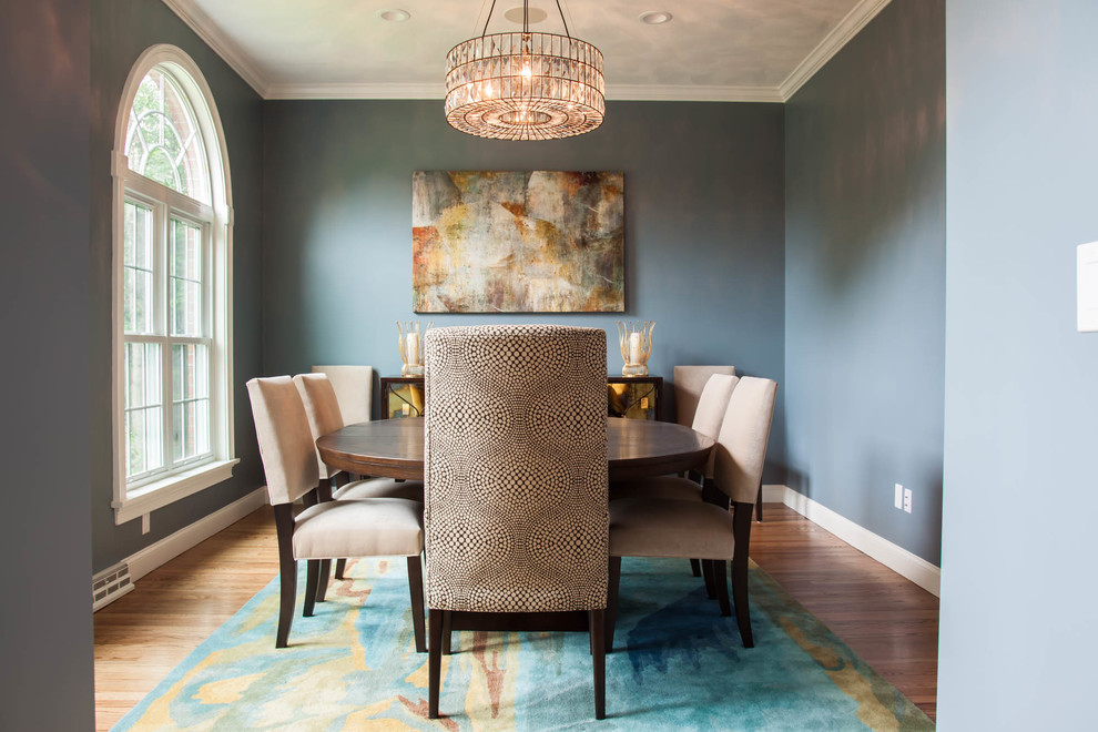 Idée de décoration pour une salle à manger tradition fermée avec un mur bleu, un sol en bois brun et aucune cheminée.