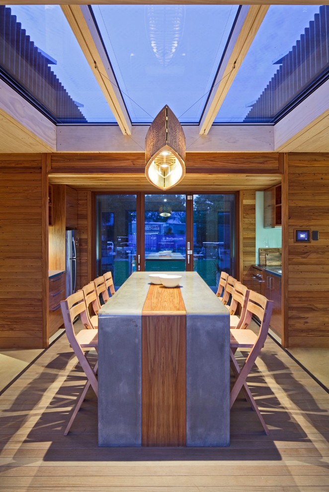 This is an example of a medium sized beach style open plan dining room in DC Metro with brown walls and light hardwood flooring.
