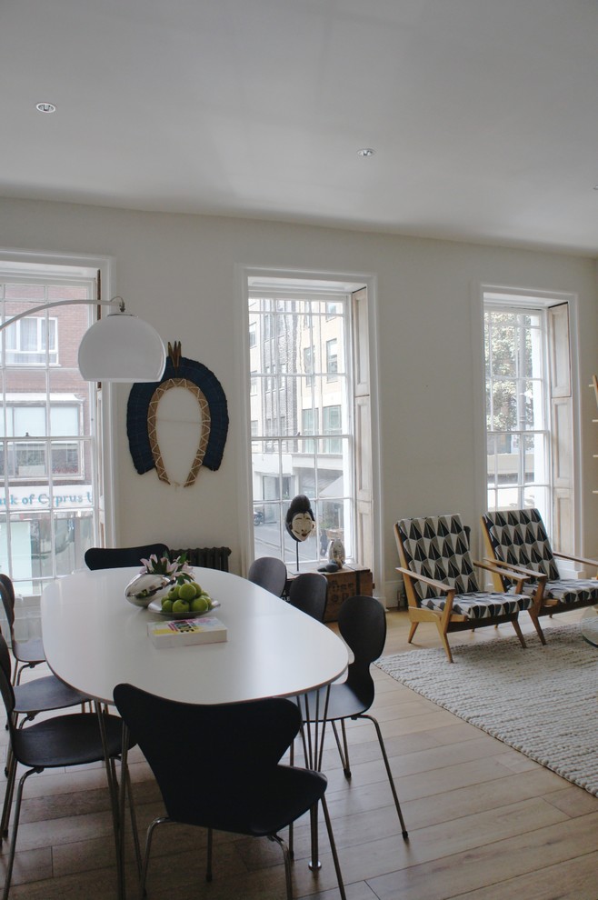 На фото: гостиная-столовая среднего размера в стиле модернизм с белыми стенами и светлым паркетным полом с