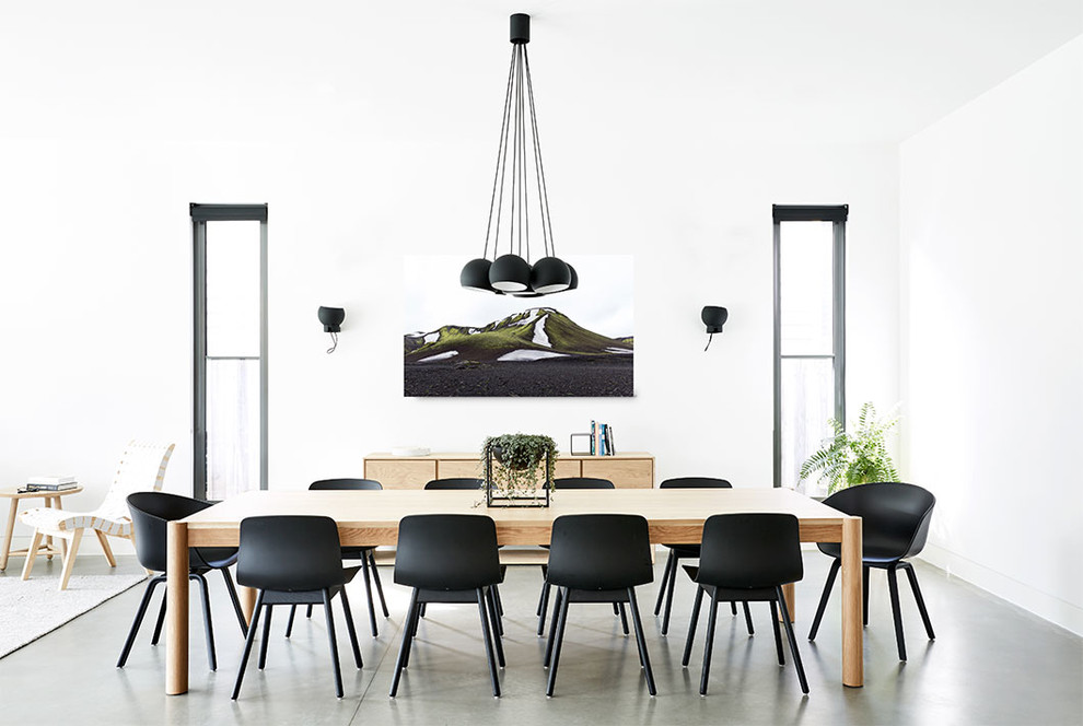 This is an example of a modern dining room in Melbourne with concrete flooring.