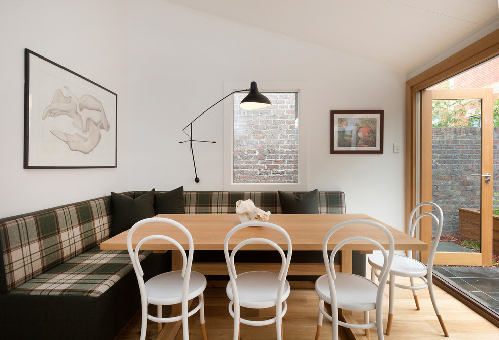 Idée de décoration pour une petite salle à manger ouverte sur la cuisine bohème avec un mur blanc, parquet clair et éclairage.