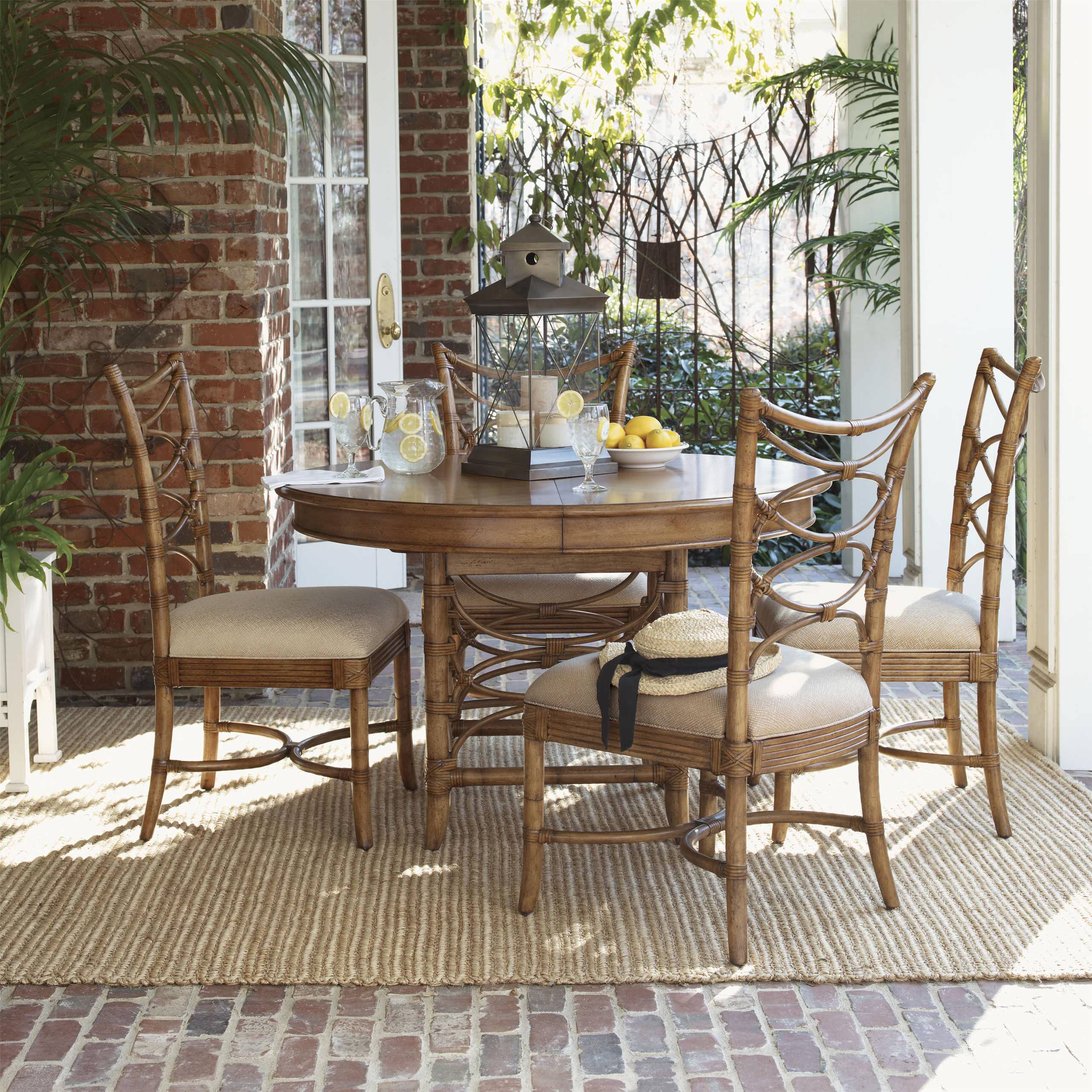 The stylish dining room with round table, rattan chair, dog on the carpet,  poster and kitchen accessories. Beige wall with mock up poster. Home decor.  Template. Stock Photo