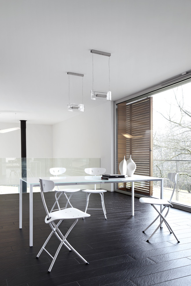 Esempio di una sala da pranzo minimalista chiusa e di medie dimensioni con pareti bianche, pavimento nero e pavimento in ardesia