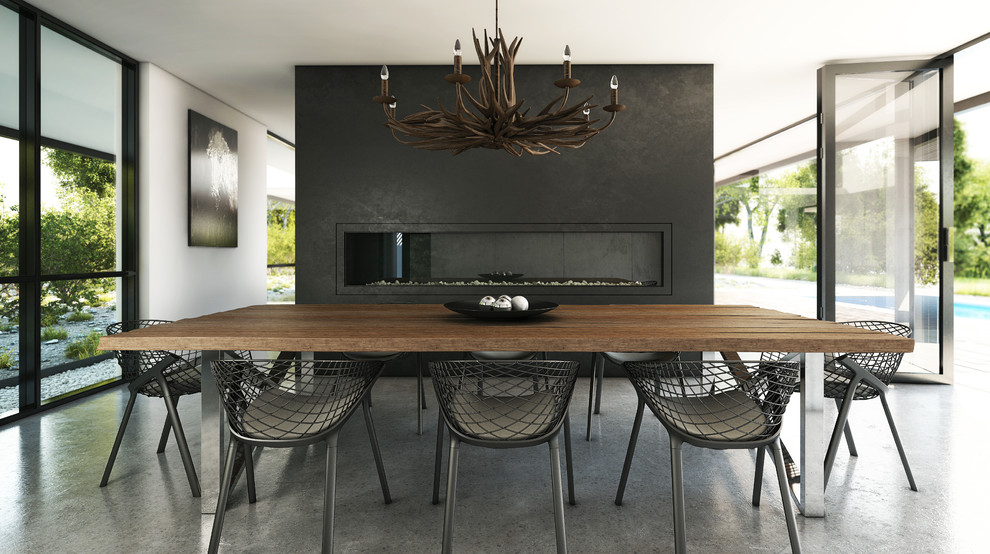 Foto de comedor minimalista grande sin chimenea con suelo de cemento, marco de chimenea de yeso y paredes negras