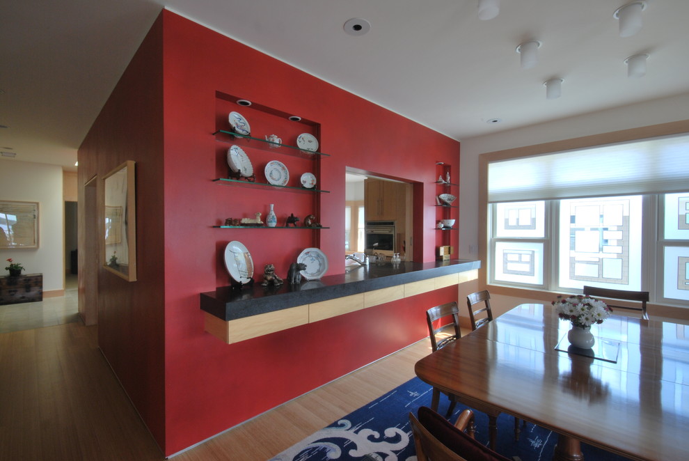 На фото: гостиная-столовая среднего размера в современном стиле с красными стенами, полом из бамбука и коричневым полом без камина с