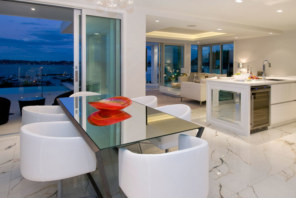 Immagine di una sala da pranzo aperta verso il soggiorno minimal con pavimento in marmo e pavimento bianco