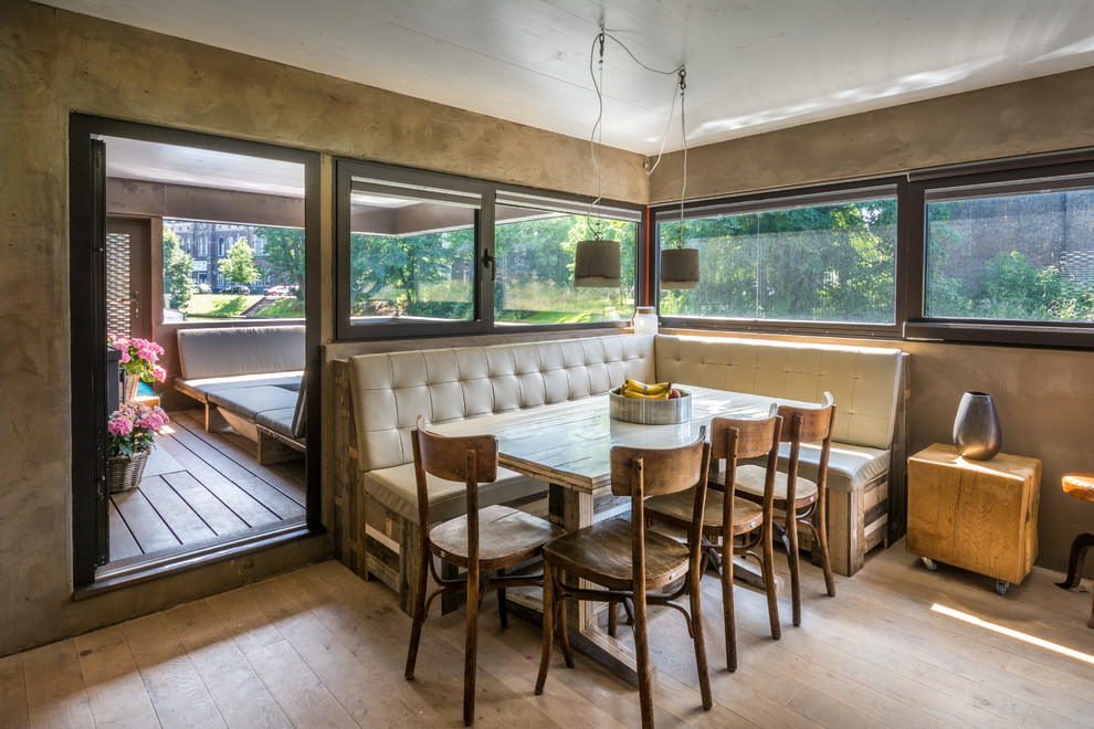 Cette image montre une petite salle à manger ouverte sur le salon urbaine avec un mur gris et un sol en bois brun.