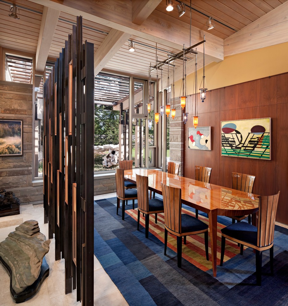 Ispirazione per una sala da pranzo aperta verso il soggiorno minimal di medie dimensioni con pareti gialle, pavimento in travertino, pavimento beige e nessun camino