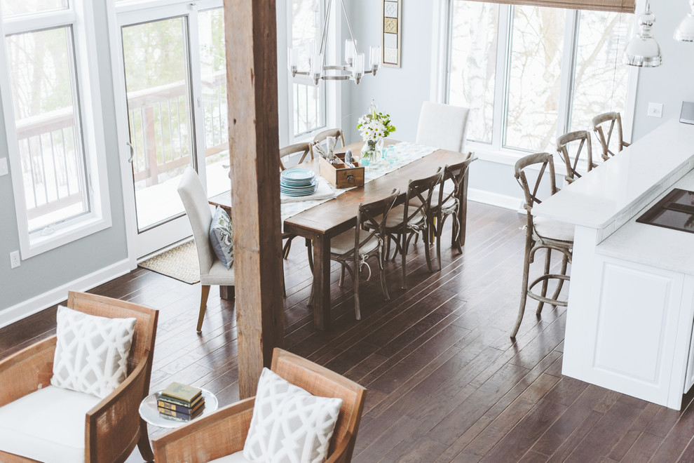 Immagine di una sala da pranzo aperta verso la cucina country di medie dimensioni con pareti bianche, parquet scuro, nessun camino e pavimento marrone