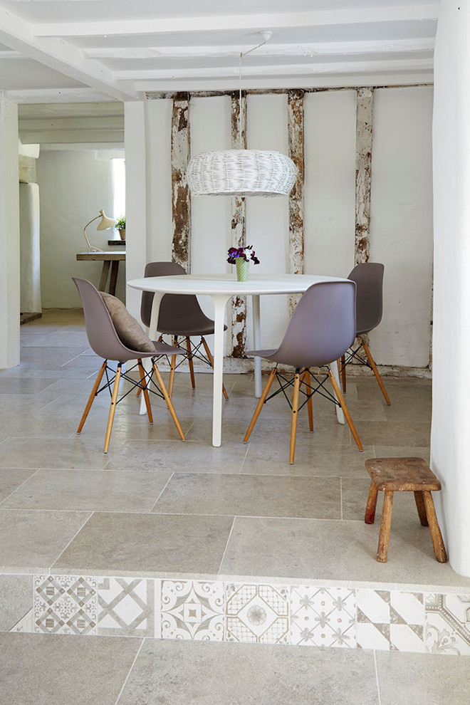 Exemple d'une salle à manger ouverte sur le salon tendance de taille moyenne avec un mur blanc et un sol en calcaire.