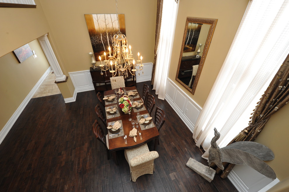 Immagine di una sala da pranzo aperta verso il soggiorno tradizionale di medie dimensioni con pareti beige, parquet scuro e pavimento marrone