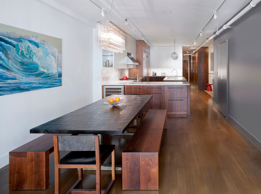 Immagine di una sala da pranzo aperta verso la cucina minimalista di medie dimensioni con pareti grigie, pavimento in legno massello medio, nessun camino e pavimento marrone