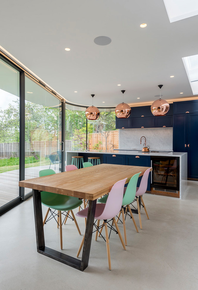 Esempio di una sala da pranzo aperta verso il soggiorno minimal di medie dimensioni con pavimento in cemento e pavimento grigio