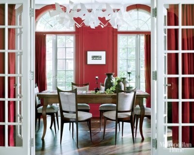 This is an example of a medium sized modern enclosed dining room in New York with red walls and dark hardwood flooring.