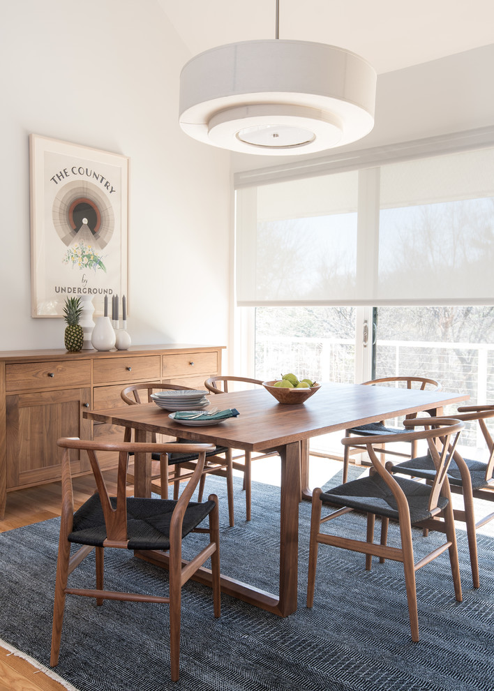 Foto di una sala da pranzo minimal di medie dimensioni con pareti bianche, nessun camino, pavimento in legno massello medio e pavimento marrone