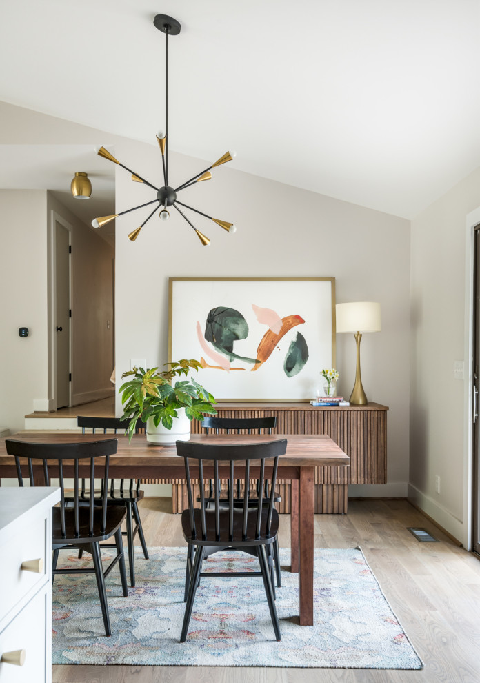 Example of a mid-sized mid-century modern medium tone wood floor and vaulted ceiling kitchen/dining room combo design in Nashville with white walls