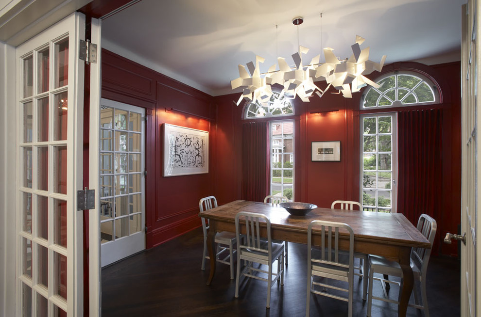 Example of a mid-sized trendy dark wood floor enclosed dining room design in New York with red walls