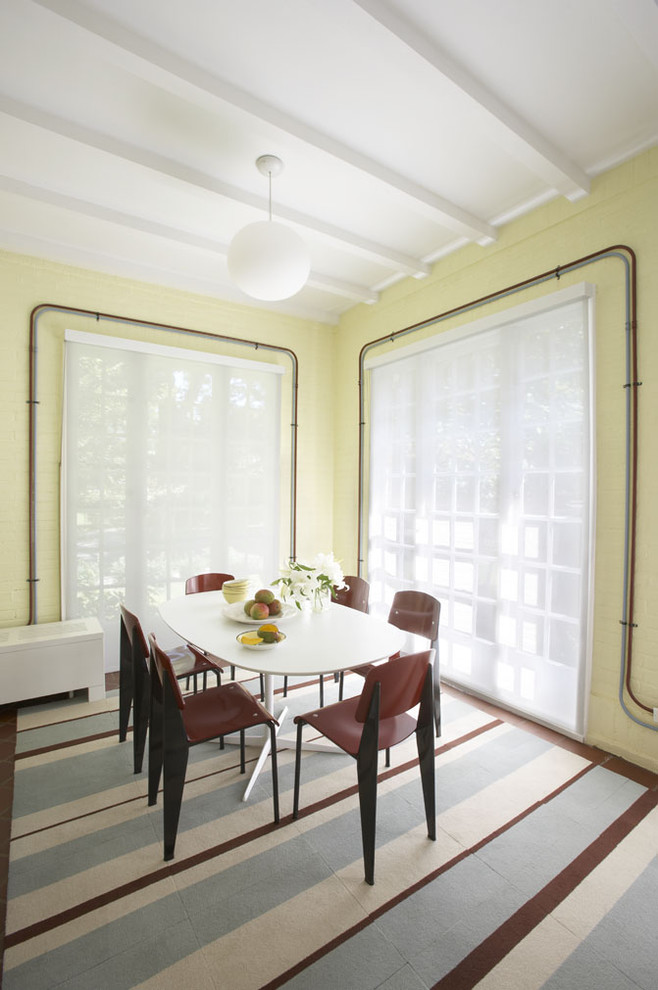 Réalisation d'une salle à manger ouverte sur la cuisine minimaliste de taille moyenne avec un mur jaune et un sol en bois brun.