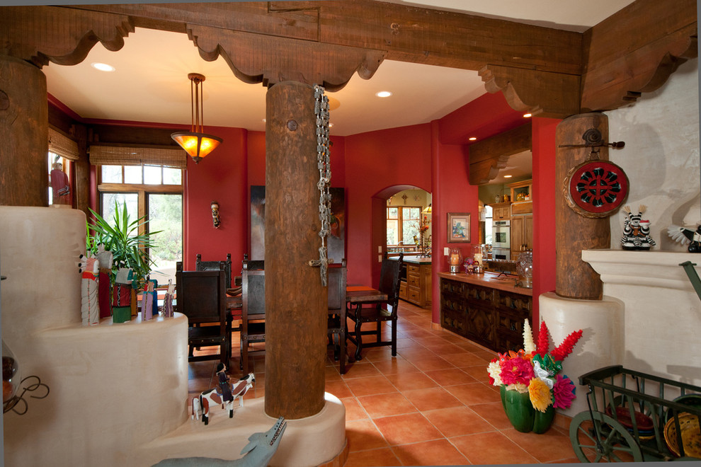Immagine di un'ampia sala da pranzo stile americano con pareti rosse e pavimento in cemento