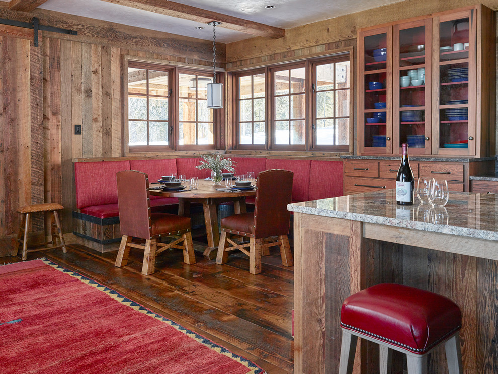 На фото: кухня-столовая в стиле рустика с коричневыми стенами и паркетным полом среднего тона