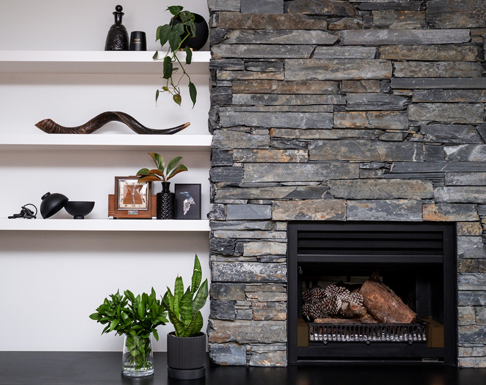 Ejemplo de comedor actual con paredes grises, suelo de madera en tonos medios, chimenea de doble cara, marco de chimenea de piedra, suelo marrón y machihembrado