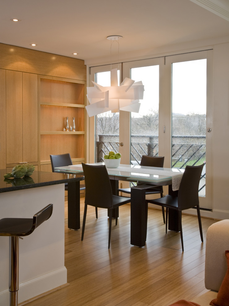 Esempio di una sala da pranzo aperta verso la cucina minimalista con pareti bianche e pavimento in legno massello medio