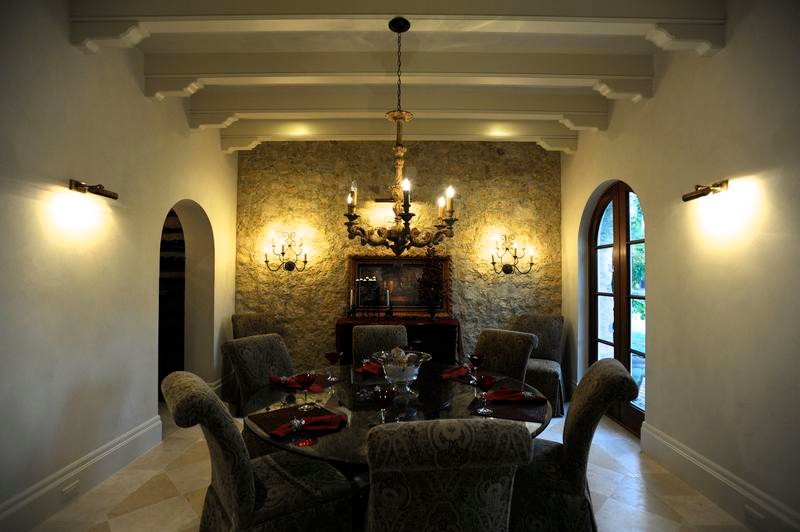Cette photo montre une salle à manger méditerranéenne fermée et de taille moyenne avec un mur blanc, un sol en calcaire et aucune cheminée.