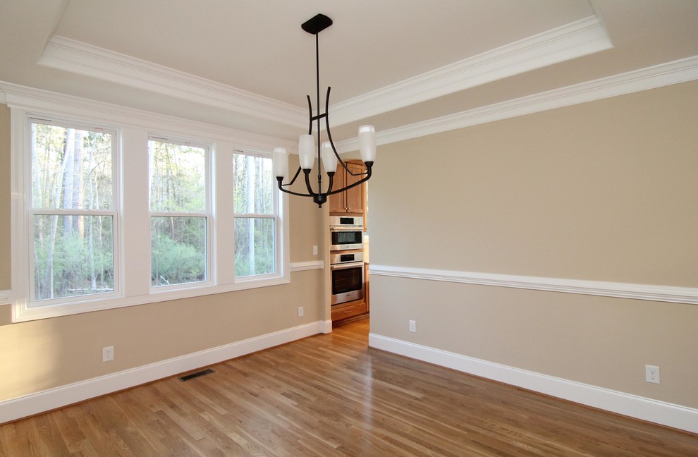 Enclosed dining room - mid-sized transitional medium tone wood floor enclosed dining room idea in Raleigh with beige walls