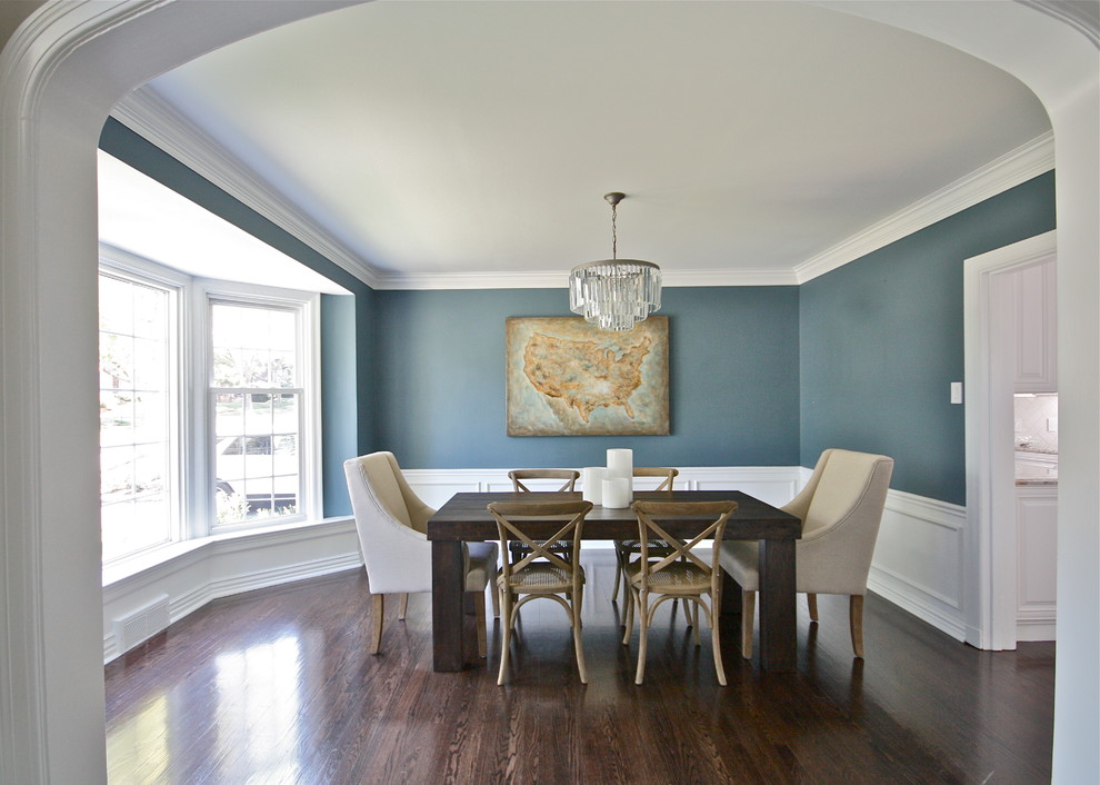 Immagine di una grande sala da pranzo aperta verso la cucina chic con pareti blu, parquet scuro e nessun camino
