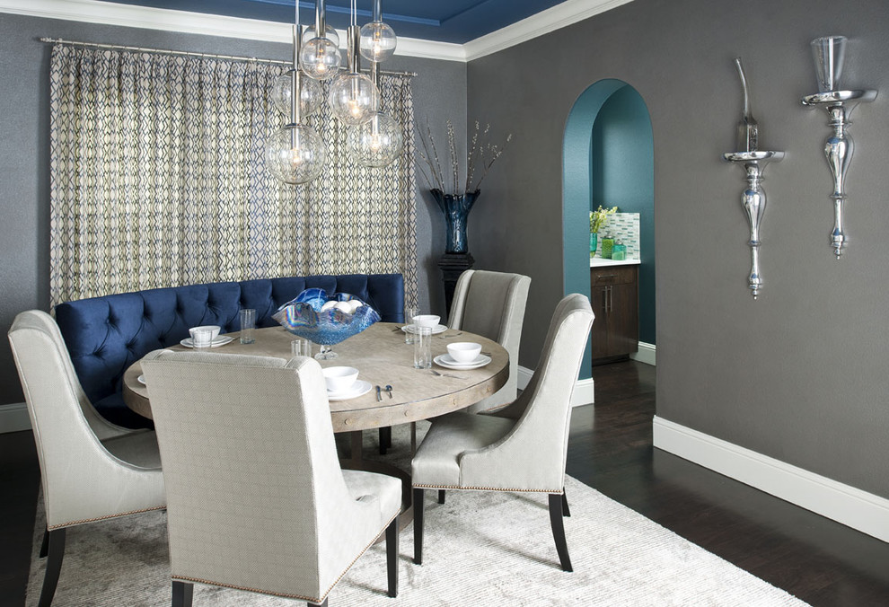 Cette image montre une salle à manger design avec un mur gris et parquet foncé.