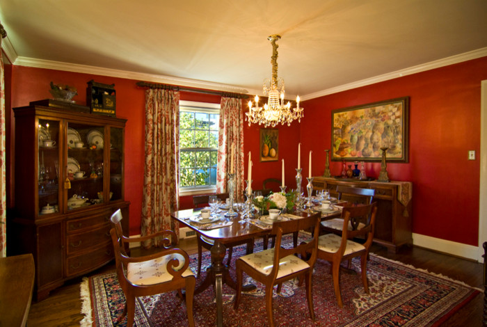 Medium sized classic enclosed dining room in Charlotte with red walls, dark hardwood flooring and brown floors.