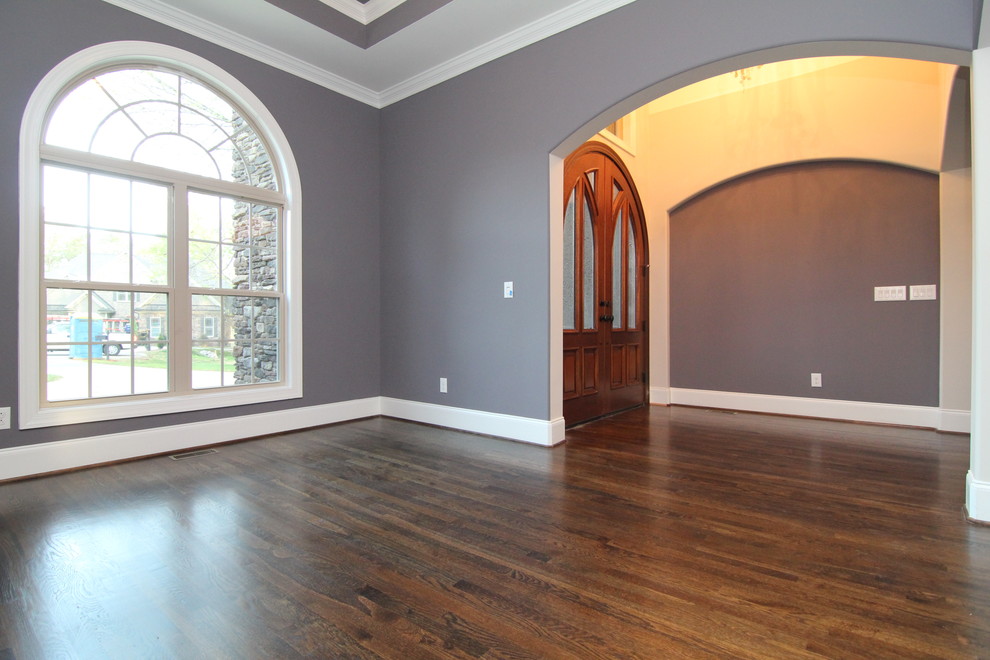 Immagine di una grande sala da pranzo aperta verso il soggiorno chic con pareti grigie e parquet scuro