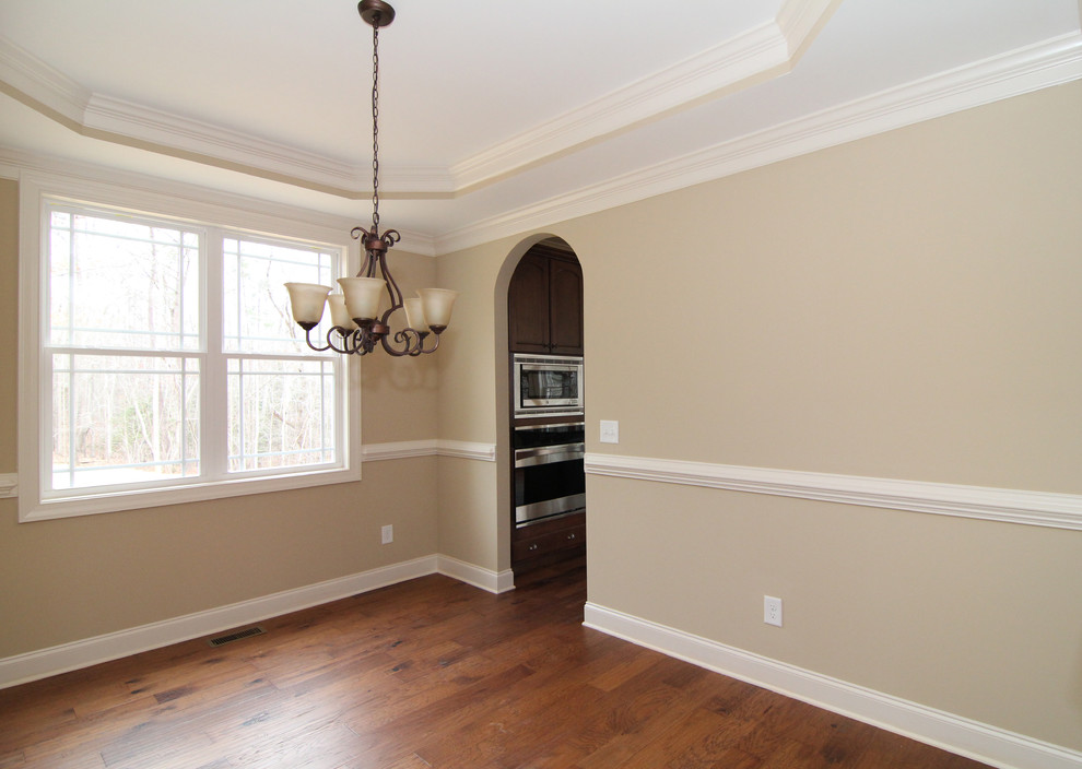 Enclosed dining room - mid-sized traditional medium tone wood floor enclosed dining room idea in Raleigh with beige walls