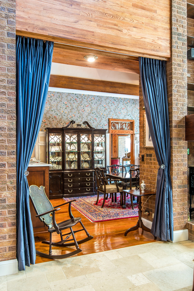 Источник вдохновения для домашнего уюта: большая отдельная столовая в классическом стиле с коричневыми стенами, паркетным полом среднего тона, двусторонним камином, фасадом камина из кирпича и красным полом