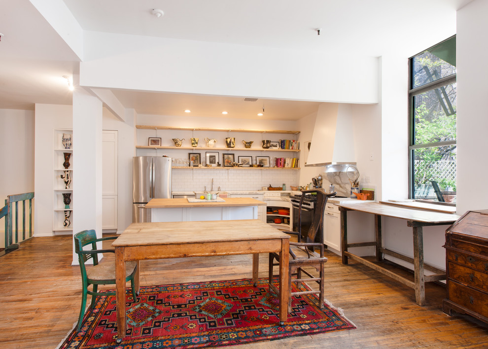 Foto di una sala da pranzo aperta verso la cucina bohémian di medie dimensioni con pareti bianche, pavimento in legno massello medio, nessun camino e pavimento beige