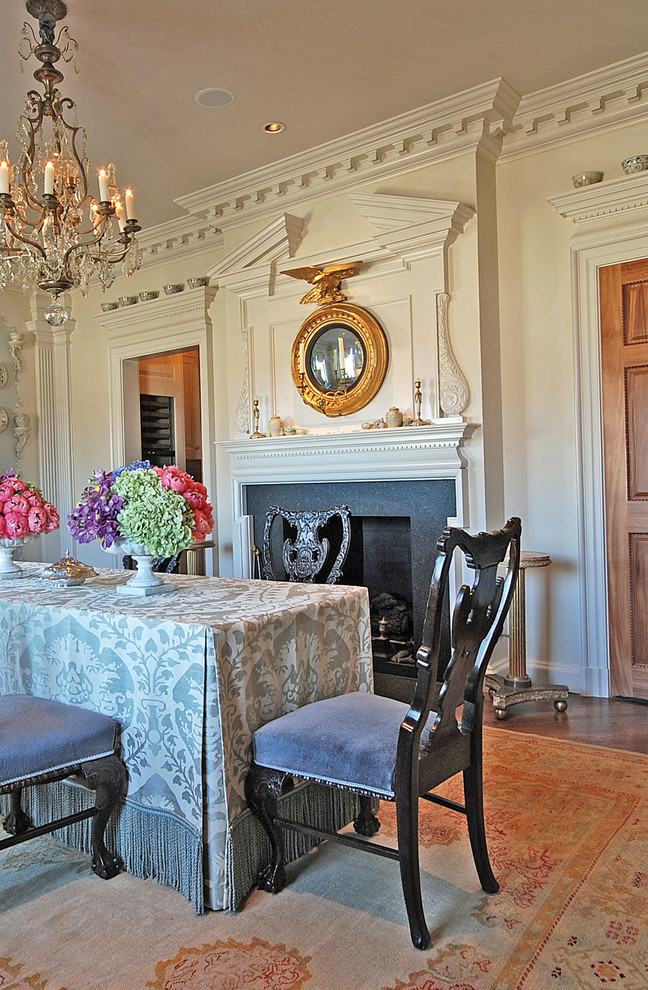 Example of a classic dark wood floor dining room design in Dallas with white walls and a standard fireplace