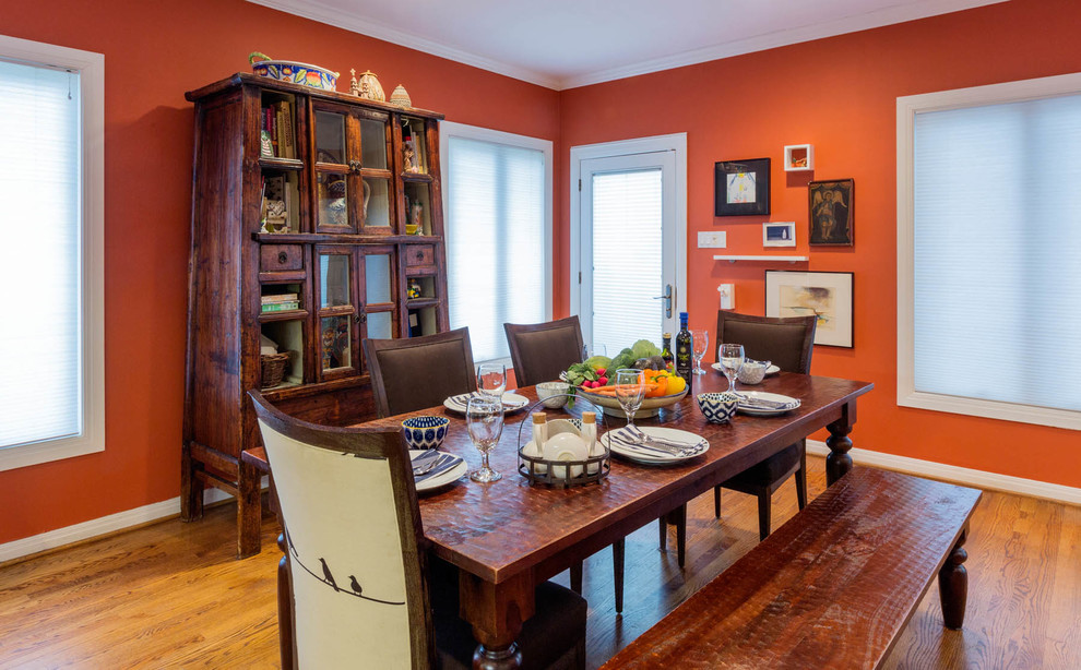 Ispirazione per una sala da pranzo eclettica chiusa e di medie dimensioni con pareti arancioni e pavimento in legno massello medio