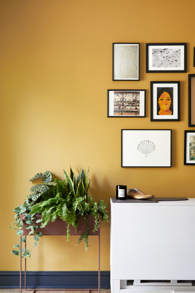Idée de décoration pour une petite salle à manger ouverte sur le salon design avec un mur jaune.