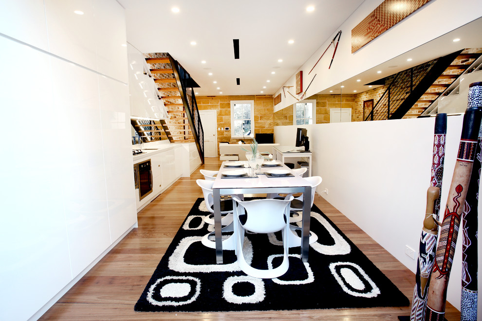Esempio di una sala da pranzo design con pareti bianche, pavimento in legno massello medio e nessun camino