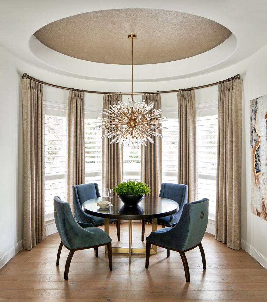 Example of a mid-sized transitional light wood floor and gray floor kitchen/dining room combo design in Austin with white walls, a ribbon fireplace and a stone fireplace