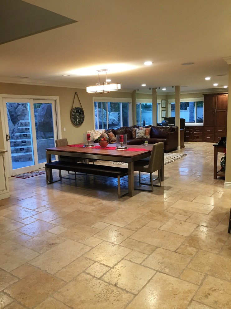 Immagine di un'ampia sala da pranzo aperta verso il soggiorno classica con pavimento in travertino, pareti marroni, nessun camino e pavimento marrone