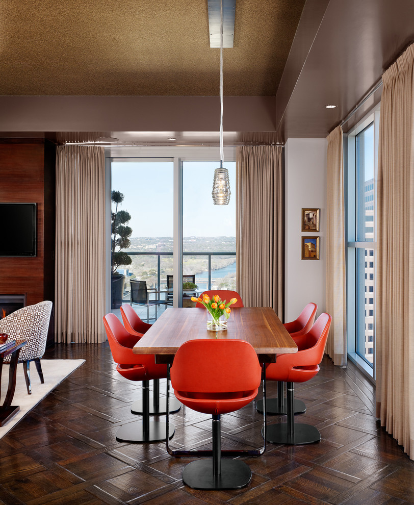 Mittelgroßes, Offenes Modernes Esszimmer mit braunem Holzboden, beiger Wandfarbe, Kamin, Kaminumrandung aus Holz und braunem Boden in Austin