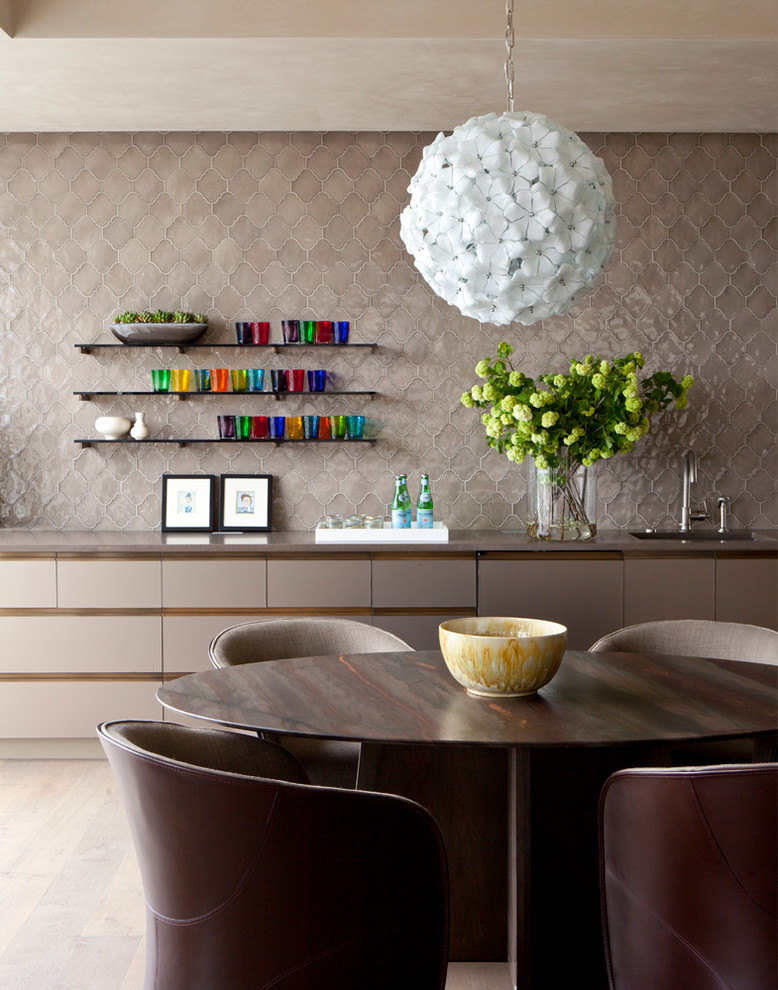 Immagine di una grande sala da pranzo aperta verso la cucina minimal con parquet chiaro, pareti beige e nessun camino