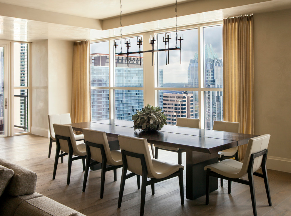 This is an example of a large contemporary kitchen/dining room in Austin with beige walls and medium hardwood flooring.