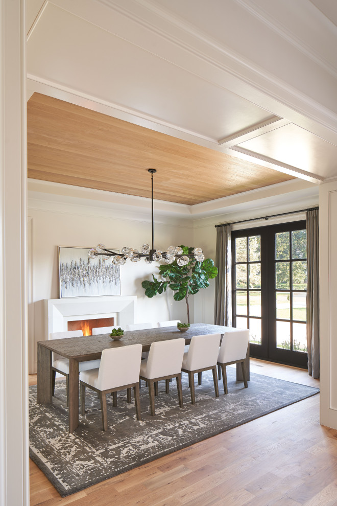 Idée de décoration pour une salle à manger avec un mur blanc, un sol en bois brun, une cheminée standard, un sol blanc et un plafond en bois.