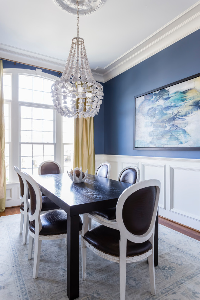 Klassisches Esszimmer mit blauer Wandfarbe, braunem Holzboden, braunem Boden und vertäfelten Wänden in Raleigh