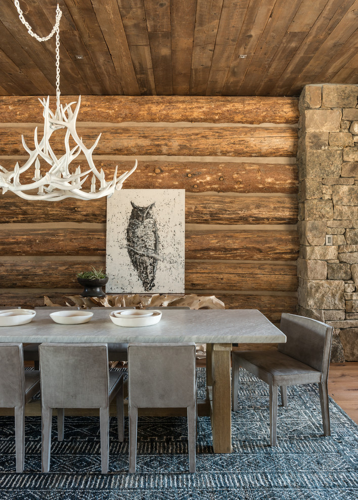 Immagine di una sala da pranzo aperta verso il soggiorno stile rurale di medie dimensioni con pareti marroni, pavimento in legno massello medio, nessun camino e pavimento marrone