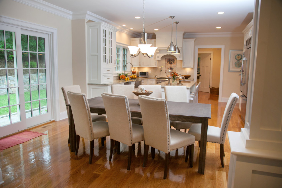 Exemple d'une salle à manger ouverte sur la cuisine chic de taille moyenne avec un mur beige, un sol en bois brun et aucune cheminée.
