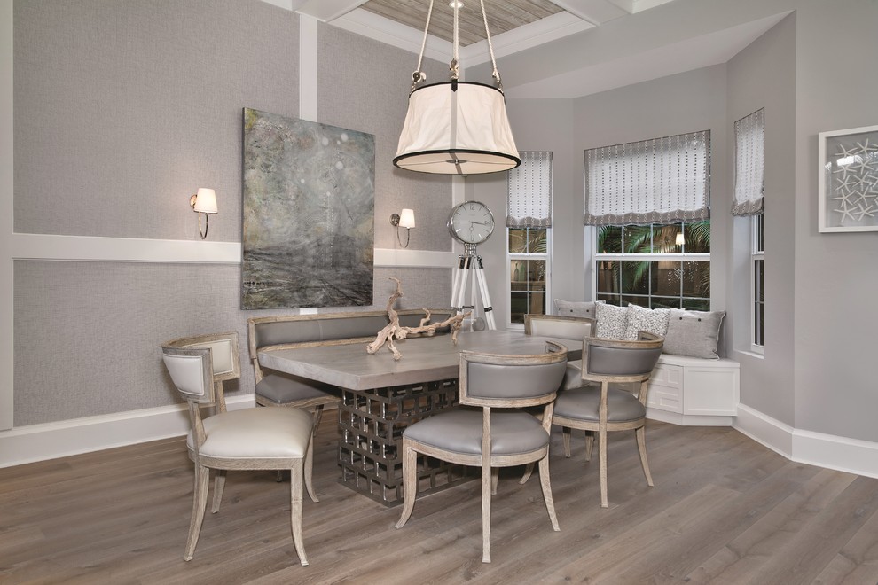 This is an example of a nautical dining room in Miami with grey walls, light hardwood flooring and beige floors.